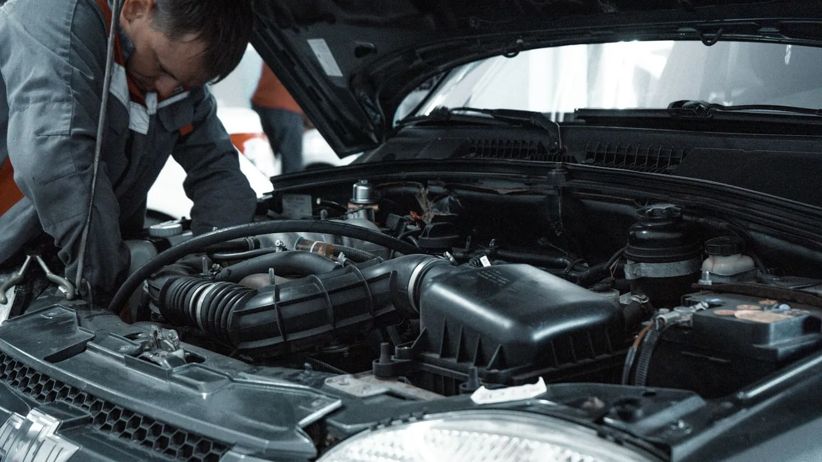 Mecánico revisando el motor de un coche con el capó abierto